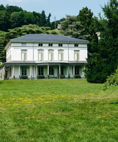 house built in a green jungle with a graden a its front